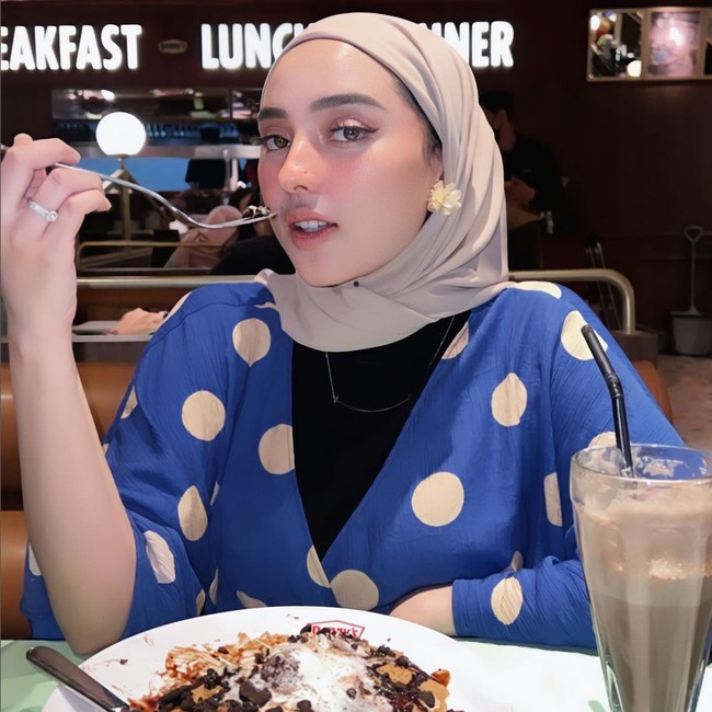 Kini Dinan kembali jadi sorotan karena gaya hijabnya. Seperti di foto ini ketika sedang menyantap pancake di sebuah restoran. Gaya hijabnya memperlihatkan sedikit bagian rambut dan telinganya.  Foto: Dok. Instagram @dinanfajrina.