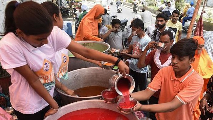India Panas Banget, Orang-orang Berebut Minum Es Youths enjoy an ice popsicle during a hot summer day in Amritsar on May 18, 2022. (Photo by NARINDER NANU / AFP) (Photo by NARINDER NANU/AFP via Getty Images)