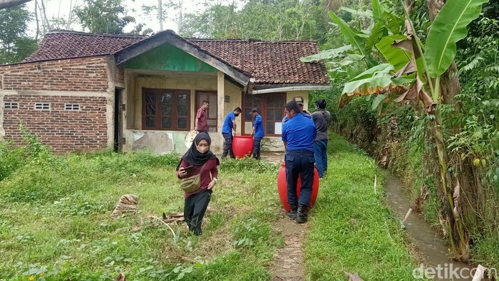 Petugas membawa tuak dalam gentong dari rumah produksi di Kelurahan Argasoka, Banjarnegara, Kamis (19/5/2022).