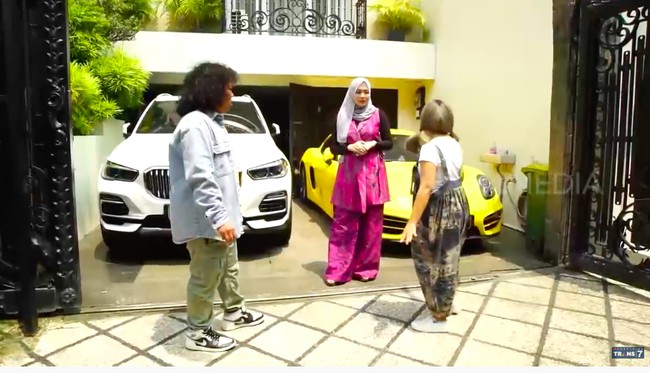 Rumah tersebut dilengkapi sebuah garasi berkonsep basement. Di depannya, terpakir dua mobil mewah milik Nadia. (Foto: YouTube/Trans7 Official)