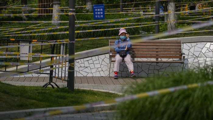Taman di China Penuh Barikade, Ada Apa? A resident pushes a child past the green space barricaded to prevent residents from gathering due to pandemic measures on Thursday, May 19, 2022, in Beijing. (AP Photo/Andy Wong)