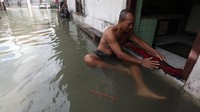 Warga berusaha membendung air rob yang memasuki rumahnya di Kalianak Timur, Surabaya, Jawa Timur, Kamis (19/5/2022).