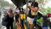 Demi menghindari hujan deras, halte bus jadi pilihan favorit warga untuk berteduh.