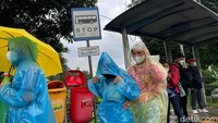 Warga berteduh di halte bus yang berada di Jalan MT Haryono, Cawang, Jakarta.
