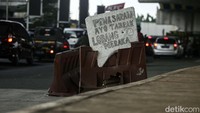 Lubang yang cukup besar dan dalam ditandai warga dengan meletakkan road barrier dan sebuah tulisan.