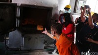 Salah satu tersangka memasukkan barang bukti narkoba ke dalam insinerator.