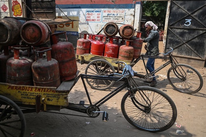 Becak India A man uses an umbrella for shade as he carries a dismantled car on a cycle rickshaw to a scrapyard on a hot weather day on the outskirts of Ahmedabad, India, May 19, 2022. REUTERS/Amit Dave TPX IMAGES OF THE DAY