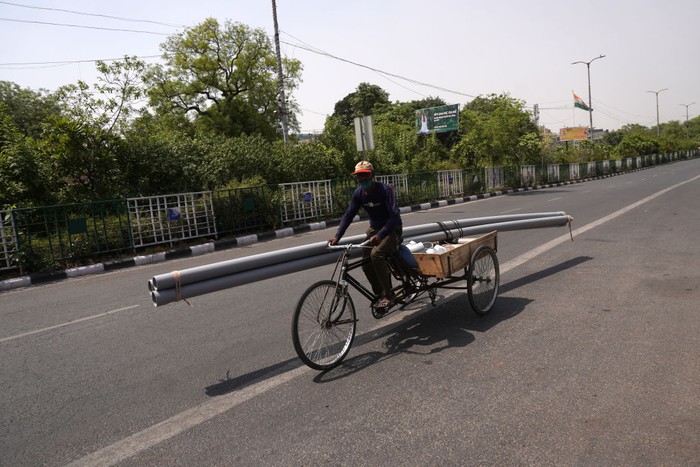 Becak India A man uses an umbrella for shade as he carries a dismantled car on a cycle rickshaw to a scrapyard on a hot weather day on the outskirts of Ahmedabad, India, May 19, 2022. REUTERS/Amit Dave TPX IMAGES OF THE DAY