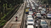 Pemotor menerobos jalur busway untuk menghindari kemacetan. 