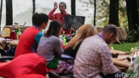 Pemandu wisata bercerita sambil menunjukkan foto Candi Borobudur.
