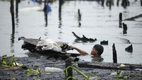 Warga nekat masuk ke dalam danau demi mengumpulkan sisa-sisa kebakaran yang masih dapat diselamatkan.