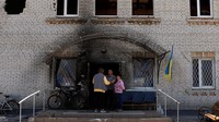 Warga berbicara di luar aula komunitas yang hancur, ketika penduduk desa kembali ke desa Moshchun, di tengah invasi Rusia, wilayah Kyiv.