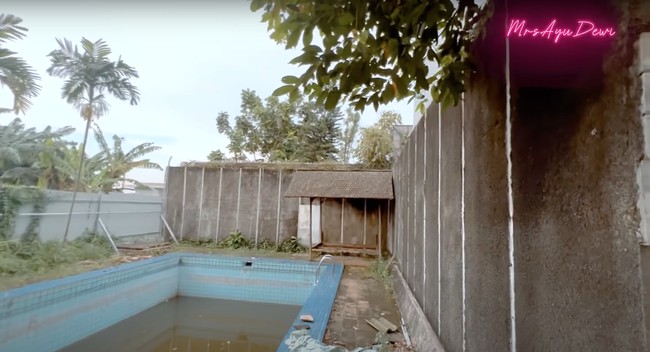 Pada bagian belakang rumah terdapat kolam renang yang cukup luas. Di dekat kolam renang tersebut terlihat sebuah pendopo yang sudah usang. Foto: YouTube/Ayu Dewi
