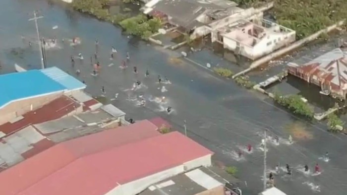 Tangkapan layar pemuda tawuran di tengah jalan yang digenangi banjir rob.