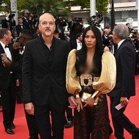 Busana tersebut hadir dengan lengan emas bervolume yang meninggalkan kesan glamor. Clutch senada turut menemani gayanya. (Foto: Stephane Cardinale-Corbis via Getty Images)