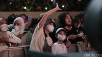 Pasangan ibu-anak itu tampak sangat menikmati penampilan Jeno Cs. (Foto: Hanif/detikcom) 