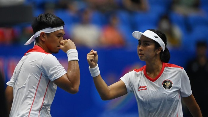 Petenis Indonesia Aldila Sutjiadi (kanan) dan pasangannya dalam tim, Christopher Rungkat (kiri) melakukan servis bola ke arah lawannya asal Thailand Patcharin Cheapchandej dan Pruchya Isaro pada babak final nomor ganda campuran tenis SEA Games 2021 Vietnam di Hanaka Paris Ocean Park, Bac Ninh, Vietnam, Jumat (20/5/2022). Christo dan Aldila berhasil meraih medali emas nomor tersebut setelah mengalahkan lawannya dengan skor 6-7 (7-9), 6-2, dan (10-5). ANTARA FOTO/Aditya Pradana Putra/foc.
