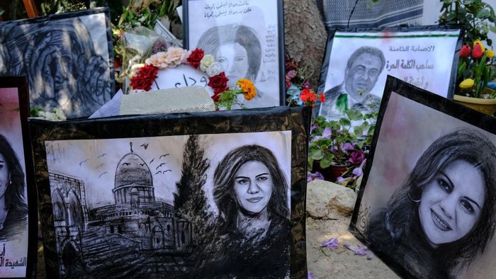 Pameran Sederhana untuk Mengenang Shireen Abu Aqleh di Palestina Palestinian schoolgirls approach a drawing on May 19, 2022 at an art exhibit honouring slain Al-Jazeera journalist Shireen Abu Akleh (portraits) at the spot where she was killed on May 11 while covering an Israeli army raid in Jenin in the occupied West Bank. (Photo by RONALDO SCHEMIDT / AFP) (Photo by RONALDO SCHEMIDT/AFP via Getty Images)