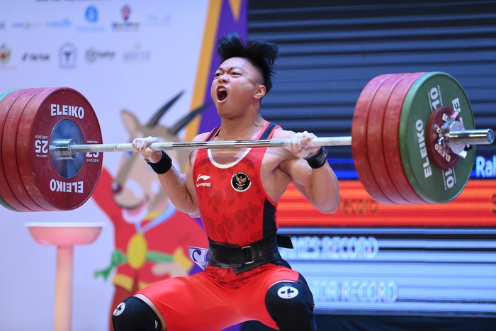 Lifter Indonesia Rahmat Erwin Abdullah melakukan angkatan clean and jerk pada final angkat besi nomor 73 Kg putra SEA Games  2021 Vietnam di Hanoi Sports Training and Competition Center, Hanoi, Vietnam, Sabtu (21/5/2022). Rahmat Erwin Abdullah berh