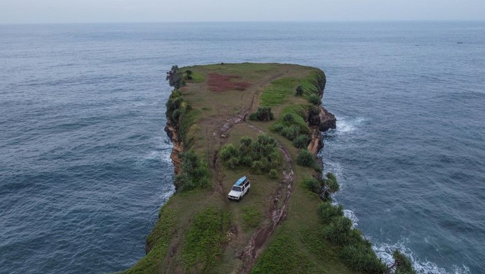 Foto aerial kawasan Pantai Karang Bolong, Pacitan, Jawa Timur, Sabtu (21/5/2022). Destinasi wisata Karang Bolong yang menyuguhkan pemandangan tebing dan pantai selatan Jawa Timur tersebut merupakan destinasi favorit di Kabupaten Pacitan. ANTARA FOTO/Hendra Nurdiyansyah/rwa.