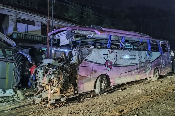 Petugas polisi berjaga jaga di dekat bus Pariwisata yang menabrak rumah warga di Payungsari, Kecamatan  Panumbangan, Kabupaten Ciamis, Jawa Barat, Sabtu (21/5/2022). Sebanyak empat orang tewas dan 24 orang luka-luka dalam kejadian tersebut. ANTARA FOTO/Iyang/ADB/hp.
