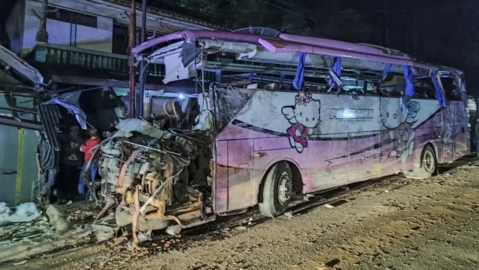 Petugas polisi berjaga jaga di dekat bus Pariwisata yang menabrak rumah warga di Payungsari, Kecamatan  Panumbangan, Kabupaten Ciamis, Jawa Barat, Sabtu (21/5/2022). Sebanyak empat orang tewas dan 24 orang luka-luka dalam kejadian tersebut. ANTARA FOTO/Iyang/ADB/hp.