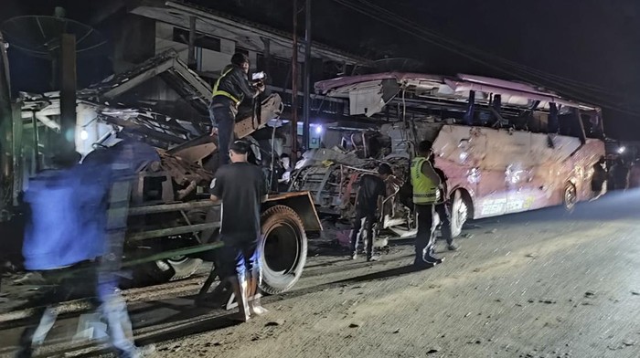 Petugas polisi berjaga jaga di dekat bus Pariwisata yang menabrak rumah warga di Payungsari, Kecamatan  Panumbangan, Kabupaten Ciamis, Jawa Barat, Sabtu (21/5/2022). Sebanyak empat orang tewas dan 24 orang luka-luka dalam kejadian tersebut. ANTARA FOTO/Iyang/ADB/hp.