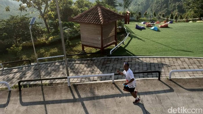 Seorang peserta lari wisata 5K melintas di wilayah perbukitan di Kendal, Minggu (22/5/2022).