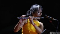 Tak hanya itu, Arina juga memainkan suling sambil berdendang seakan mengajak penonton untuk ikut bergoyang. 