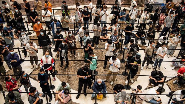 Orang-orang yang memakai masker mengantre di pembukaan resmi Apple Store baru di Wuhan International Plaza, Wuhan. (SOPA Images/LightRocket via Gett)