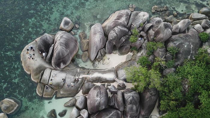 Foto udara sejumlah wisatawan beolahraga stand up paddle di Pantai Tanjung Tinggi, Belitung, Kepulauan Bangka Belitung, Sabtu (21/5/2022). Pantai yang memiliki batu Meteorit (Tektit/Satam) menjadi daya tarik wisatawan berkunjung pada hari libur. ANTARA FOTO/ Fakhri Hermansyah/hp.