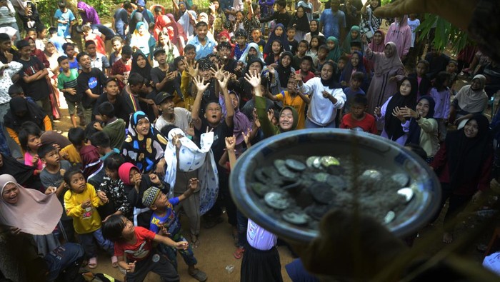 TRADISI PESTA PANEN RAYA DI MAKASSAR Sejumlah warga berebut uang koin yang dilemparkan pada Pesta Panen raya di Kelurahan Laikang, Makassar, Sulawesi Selatan, Minggu (22/5/2022). Pesta panen raya yang dilakukan tiap tahun oleh masyarakat setempat itu sebagai bentuk rasa syukur kepada Tuhan YME atas hasil panen yang melimpah serta menjadi ajang silaturahim antar warga. ANTARA FOTO/Abriawan Abhe/wsj.