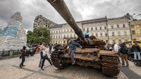 Orang-orang melihat kendaraan lapis baja di pusat kota Kyiv, Ukraina, Minggu (22/5/2022) waktu setempat.  