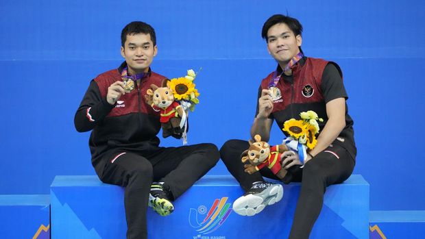 Indonesia's Daniel Marthin, right, and Leo Rolly Carnando celebrate with their gold medals after defeating compatriots Pramudya Kusumawardana and Yeremia Rambitan in the men's doubles badminton final match at the 31st Southeast Asian Games (SEA Games) in Bac Giang, Vietnam, Sunday, May 22, 2022. (AP Photo/Achmad Ibrahim)