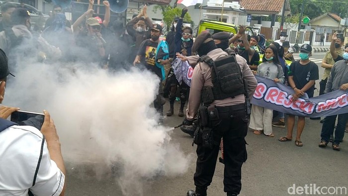 Polisi memadamkan ban bekas yang dibakar demonstran di Pemalang, Senin (23/5/2022).