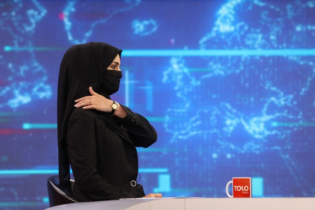 Selama pemerintahan terakhir Taliban dari tahun 1996 hingga 2001, wajib bagi wanita untuk mengenakan burqa biru yang menutupi semua wajah. Sedangkan di masa sekarang, menurut Mahajar, presenter wanita di Afghanistan bisa memakai masker wajah medis, seperti yang telah banyak digunakan selama pandemi COVID-19. Foto: REUTERS/ALI KHARA.