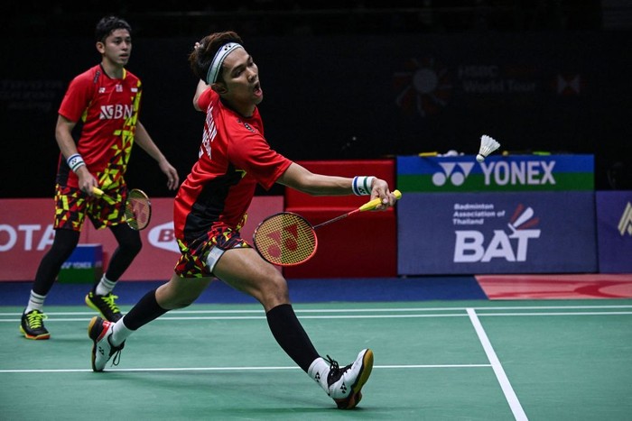 Indonesias Fajar Alfian (R) hits a return alongside partner Muhammad Rian Ardianto during their mens doubles semi-final match against Malaysias Aaron Chia and Soh Wooi Yik at the 2022 Thailand Open badminton tournament in Bangkok on May 21, 2022. (Photo by Lillian SUWANRUMPHA / AFP) (Photo by LILLIAN SUWANRUMPHA/AFP via Getty Images)