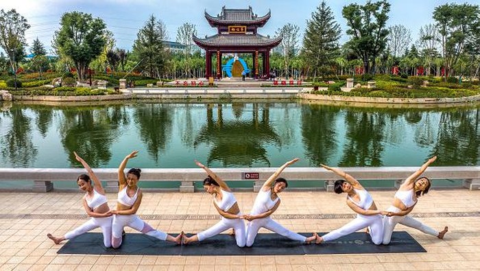 Gemulai Gerakan Yoga dengan Pesona Taman yang Indah YUNCHENG, CHINA - MAY 22: Yoga enthusiasts practice yoga at a park on May 22, 2022 in Yuncheng, Shanxi Province of China. (Photo by Xue Jun/VCG via Getty Images)