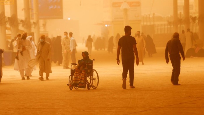 A child sweeps the floor during a sandstorm at the Imam Ali Shrine in Najaf, Iraq, May 23, 2022. REUTERS/Alaa Al-Marjani