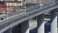 Para pebalap melintasi Jembatan San Giorgio pada etape ke-12 yang menempuh jarak dari Kota Parma ke Genoa, (19/5/2022).  (Fabio Ferrari/LaPresse via AP)