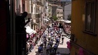 Pebalap sepeda melintasi jalanan di Kota Isernia pada etape ke-9 Giro dItalia, (15/5/2022). Lebih dari 3.000 km dilalui para pebalap dalam waktu 3 pekan. (Marco Alpozzi/LaPresse via AP)