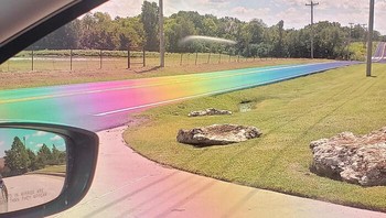 Itu adalah pantulan cahaya di kaca, bukan jalan yang dicat pelangi.