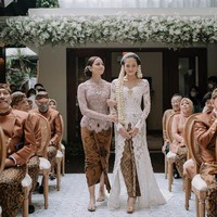 Tak kalah cantik, adik Maudy Ayunda, Amanda Khairunnisa, mengenakan kebaya warna mauve dipadu kain batik saat menggandeng sang kakak menuju tempat akad nikah. Foto: Instagram @maudyayunda