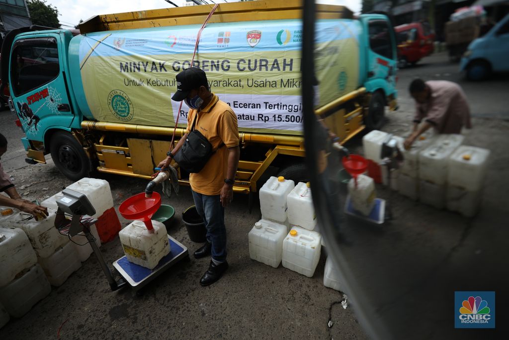 Pekerja mengisi minyak goreng curah bersubsidi ke dalam jerigen di pasar Kebayoran Lama, Jakarta, Senin (23/5/2022). Operasi pasar tersebut menyediakan minyak goreng curah subsidi sebanyak 8000 liter dengan harga Rp 14.000 per liter atau Rp 15.500 per kilogram untuk mencukupi kebutuhaan masyarakat. (CNBC Indonesoa/ Tri Susilo)