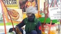 Tidak hanya mengenakan jas, dasi, dan pantofel, pedagang kerak telor ini juga punya gaya yang unik. Bedanya, ia lebih terinspirasi oleh sosok anime yang ditontonnya sejak kecil. Foto: 1cak.com