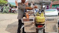 Jualan siomay dengan motornya, pedagang ini berdandan begitu rapi. Tampak seperti pejabat, ada jas abu-abu yang lengkap dengan dasi menjadi seragam untuk jualannya. Foto: 1cak.com