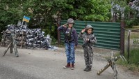 Andrii dan Valentyn memberi hormat saat bermain perang-perangan di depan rumahnya.