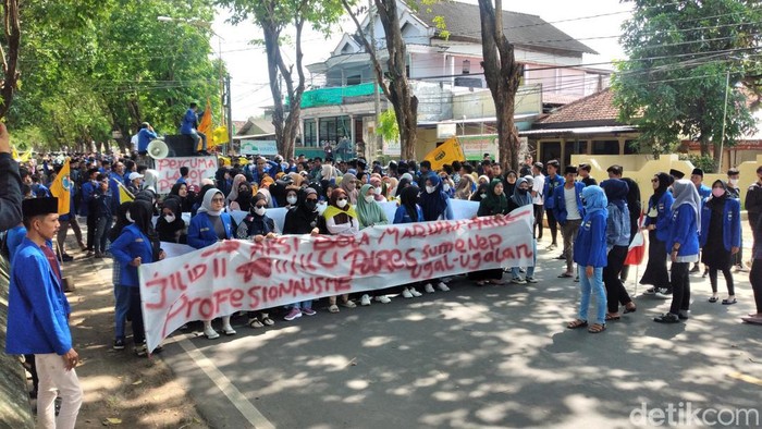 Ratusan aktivis PMII berunjuk rasa di depan Polres Sumenep. Mereka bentangkan spanduk Percuma Lapor Polisi.