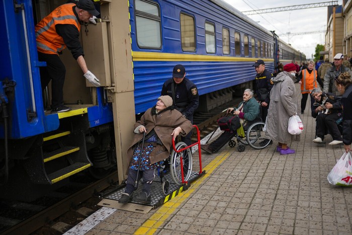 Lyubov Chudnyk, right, fleeing from heavy shelling, waits aboard an evacuation train to depart Pokrovsk train station, in Pokrovsk, eastern Ukraine, Sunday, May 22, 2022. Civilians fleeing areas near the eastern front in the war in Ukraine Sunday described scenes of devastation as their towns and villages came under sustained attack from Russian forces. (AP Photo/Francisco Seco)