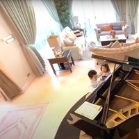 Di dekat ruang tamu tersebut terdapat sebuah piano hitam besar yang membuat ruangan jadi terlihat lebih mewah dan elegan. Piano tersebut biasanya dipakai sang anak untuk bermain sekaligus belajar. Foto: YouTube/THE TYAS FAMILY
